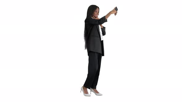 Beautiful Afroamerican Woman Smiling at Her Phone Shooting a Selfie on White Background.