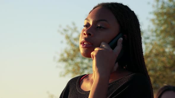 Young Beautiful Black Woman Phone in Park During Sunset - Closeup