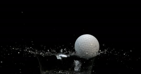 Golf's Ball Falling into Water against Black background, slow motion 4K