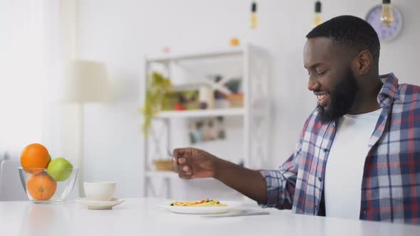 African-American Man Eating Spoiled Spaghetti on Lunch, Stomach Disease, Nausea