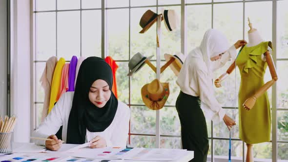 Muslim women fashion designers are in process of creating new clothes collection.