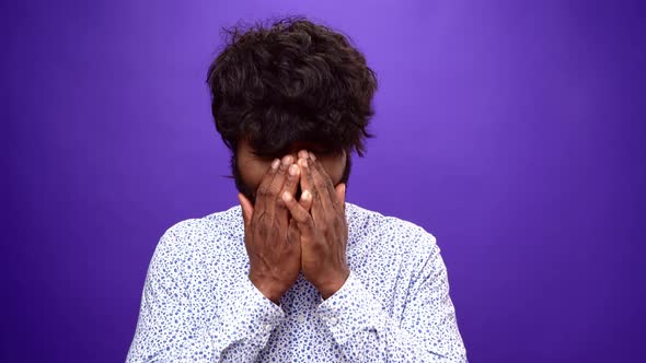 Upset African American Man Starts Crying Closing Face with Hands Purple Background
