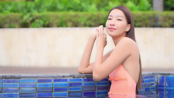 Young asian woman enjoy around outdoor swimming pool for leisure