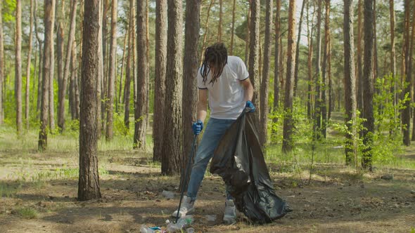 Arab Man Cleaning Up Forest From Plastic Trash