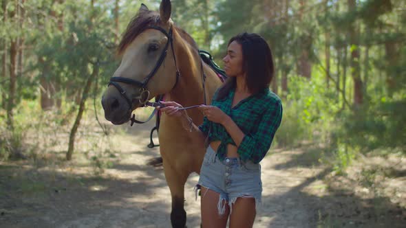 Female Rider with Purebred Horse Strolling in Wood