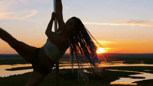 Pole Dance on Orange Sunset - Attractive Woman with Long Braids Dancing