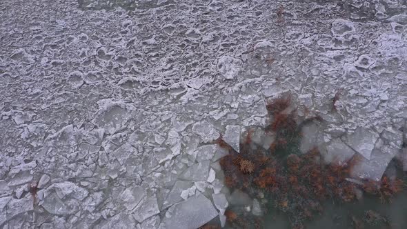 Flying down toward broken ice layers on lake in Utah