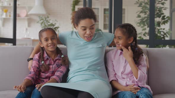 Joyful Black Mom and Daughters Having Fun on Couch