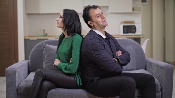 Argued Interracial Adult Couple Sitting on Couch Back to Back Talking Thinking