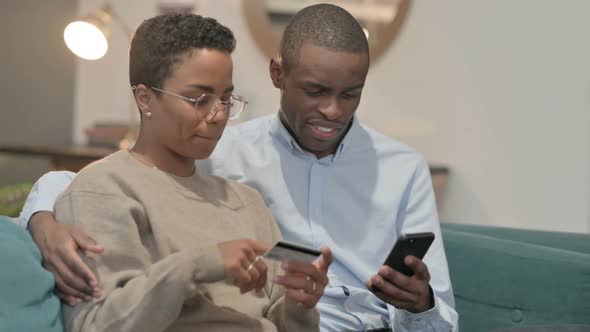 Couple Having Successful Online Shopping on Laptop on Sofa