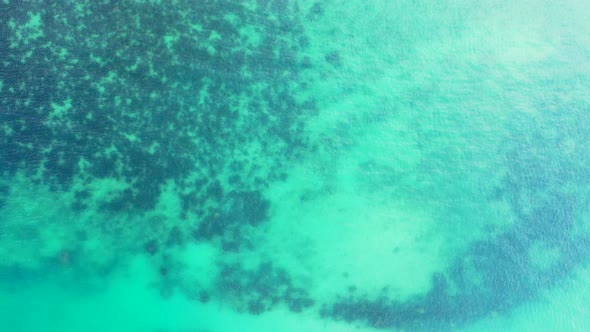 Wide angle above travel shot of a paradise sunny white sand beach and aqua turquoise water backgroun