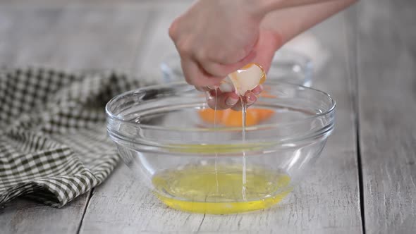 Female Hands Breaking an Egg and Separating Yolk From White.