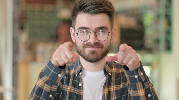 Portrait of Young Man Pointing Finger and Inviting