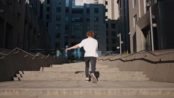 Young Man Enjoys Moment Jumping on Stairs Against Building