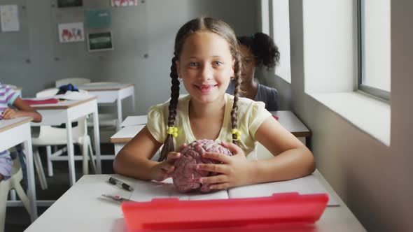 Video oh happy caucasian girl holding brain model during biology lesson