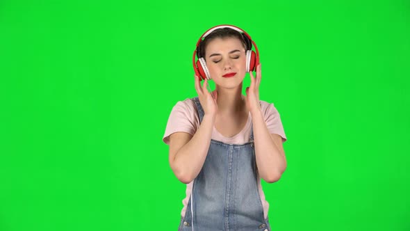 Girl Dancing in Big Red Headphones on Green Screen at Studio