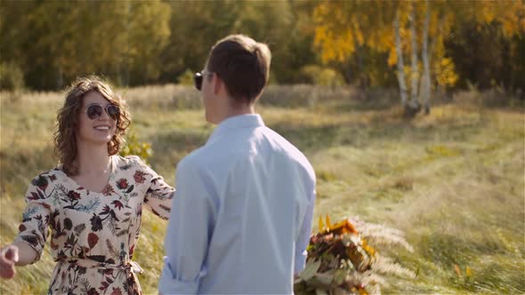 Young Couple Walking on a Meadow