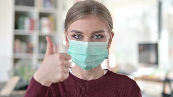 Portrait of Thumbs Up By Young Woman with Mask 