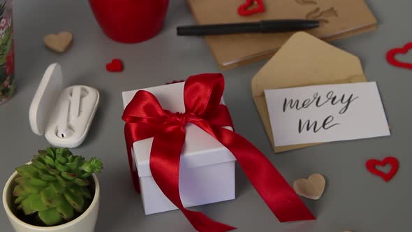 Valentine's day Present with a red ribbon bow and card MERRY ME zoom in