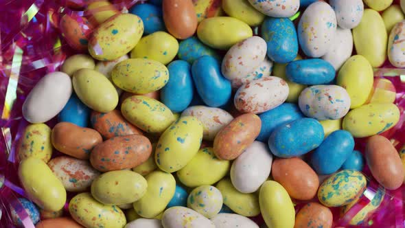 Rotating shot of colorful Easter candies on a bed of easter grass - EASTER