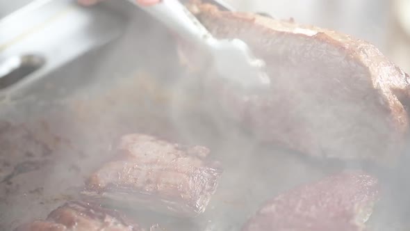 Cooking beef steaks on the stove with tongs