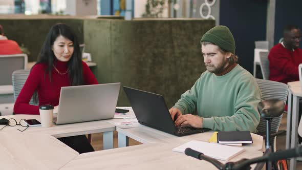 Businesspeople Working on Laptops in Coworking Space