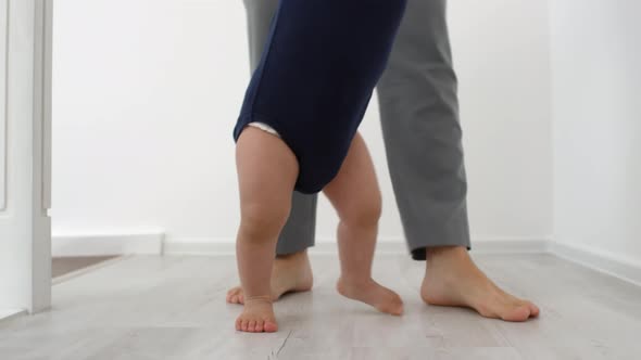 Barefoot Toddler Learning to Walk with Support