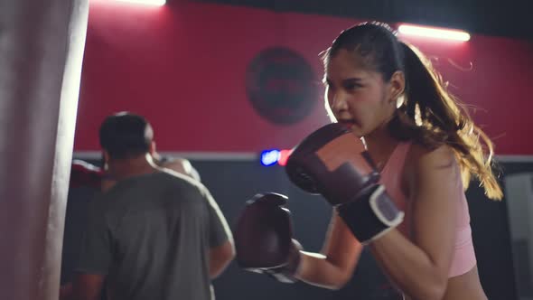 Asian professional male and female athlete people doing workout exercise punching on boxing sandbag