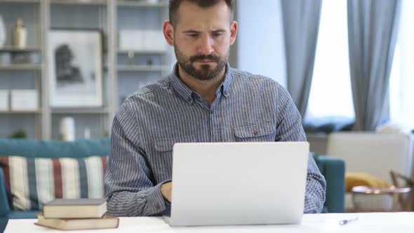 Pensive Man Thinking and Working on Laptop