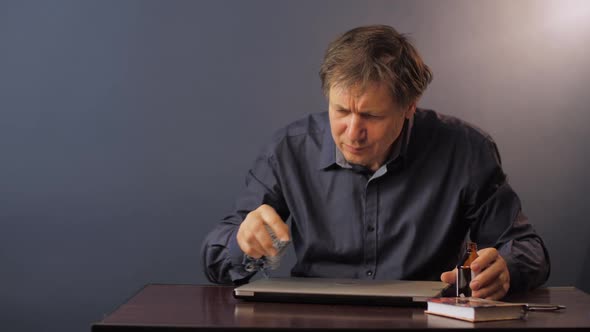 Mature Man in Shirt Clears Laptop of Dirt with Alcohol