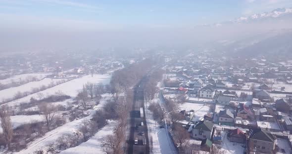 Winter Village and Highway with Cars in the Fog