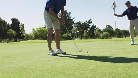 Two caucasian senior man practicing golf at golf course on a bright sunny day