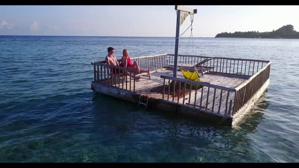 Young couple tanning on perfect sea view beach break by aqua blue lagoon with white sand background 