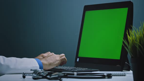 Man doctor working at pc with green screen in modern equipped lab analysing virus evolution.