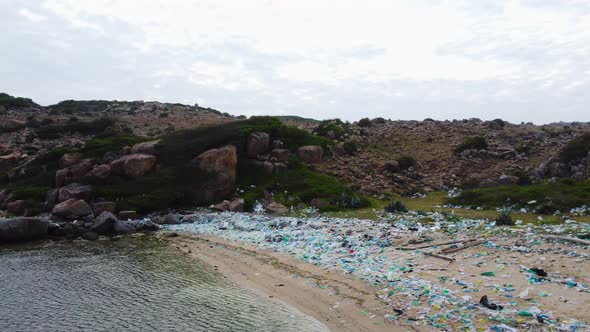 Aerial circular view of polluted beach in Ninh Thuan, full of colorful plastic bags. Nature of natio