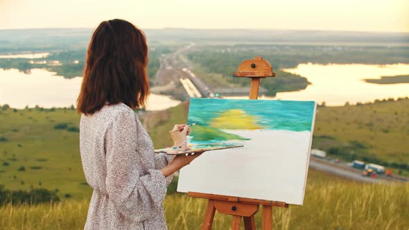 Young Woman Drawing a Painting Inspired By the Sunset