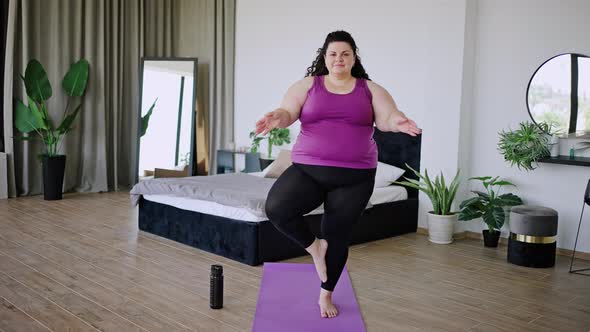 Body Positive Brunette Does Yoga on Purple Sports Mat