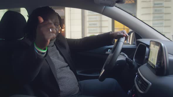 Excited African American Black Man Showing Thumb Up While Sitting on Driver Seat of His New Car