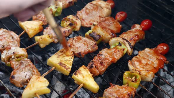 Grilled meat and vegetable skewers on charcoal stove.
