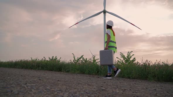 Woman Ecology Specialist with Special Equipment in Hand Goes to Service Windmill