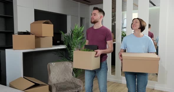 Happy Young Husband Lifting Excited Wife Celebrating Moving Day with Cardboard Boxes