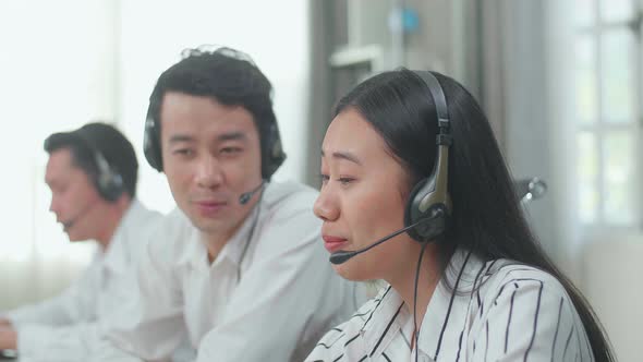 Close Up Of A Woman And A Man Of Three Asian Call Centre Agents Discussing About Work