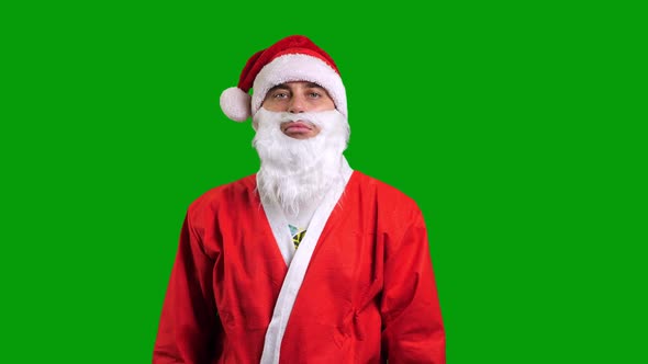 Santa Claus in Red Suit Pointing Aside to the Corner on Green Chroma Key Background