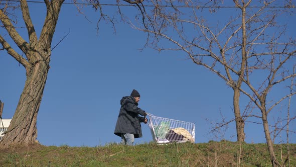 Low Angle View of Homeless Man Pushing Cart