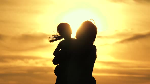 Family on Vacation. Mom Is Circling Her Beloved Healthy Little Daughter in Her Arms. Silhouette of