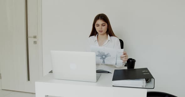 Young Girl Explaining the Topic at Laptop at Workplace in Office