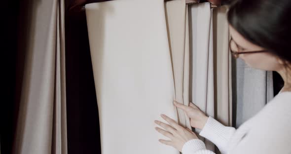 Young Woman Chooses Curtains in the Store