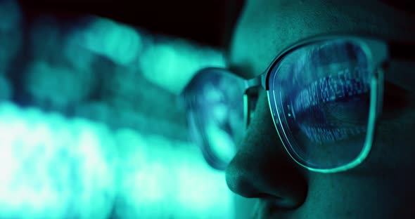 Closeup of Young Adult Female Wearing Reflective Eye Glasses Analyzing Cyber Security Code Data Work