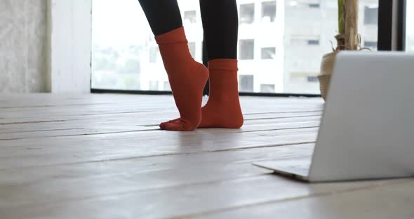 Close Up Handmade Red Wool Textile Socks on Female Legs, Woman Goes in for Sports at Home on Floor