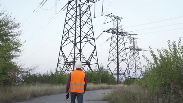 Engineer Inspects a Power Line Using Data From Electric Sensors on a Tablet